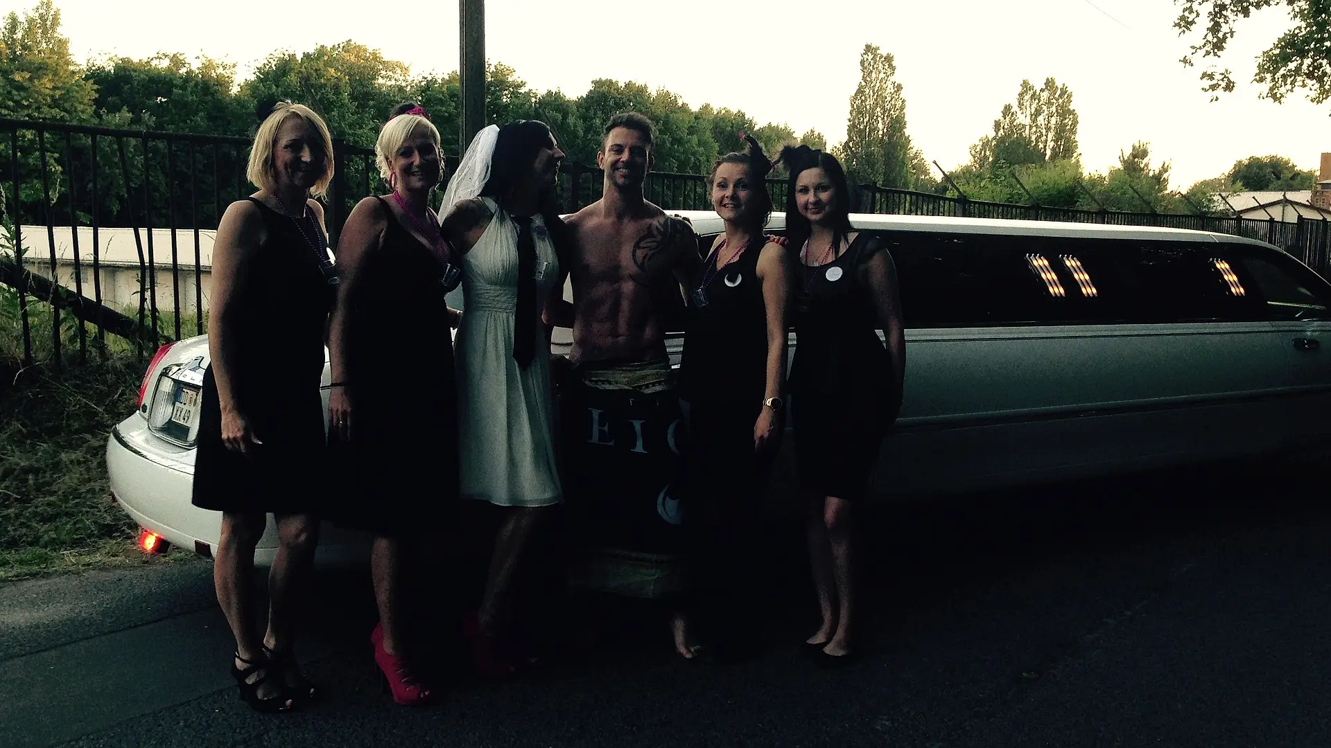 Gruppe mit Stripper vor einer Limousine