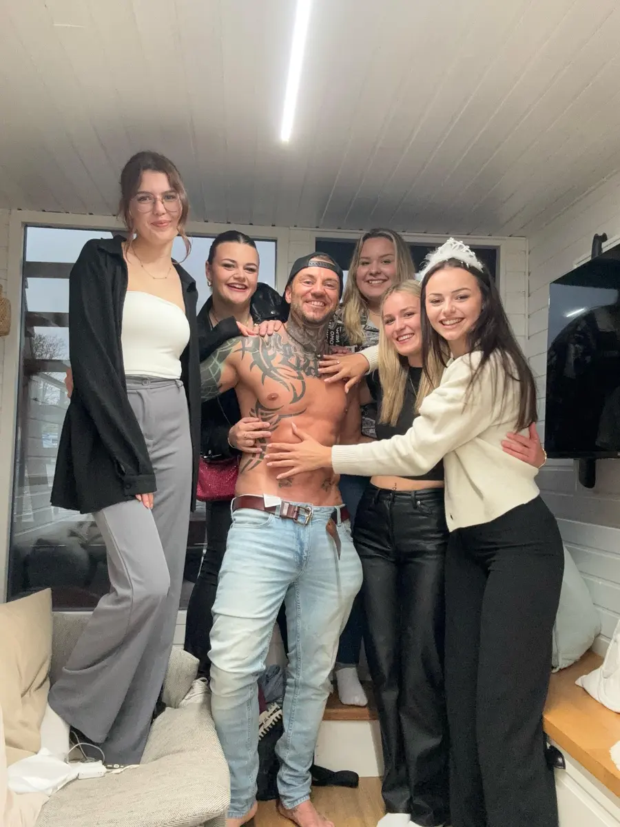 Gruppe feiert mit Stripper im Wohnzimmer